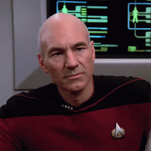 A Man In A Star Trek Uniform Has A Badge On His Chest GIF