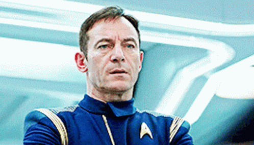 a man in a star trek uniform is looking at something