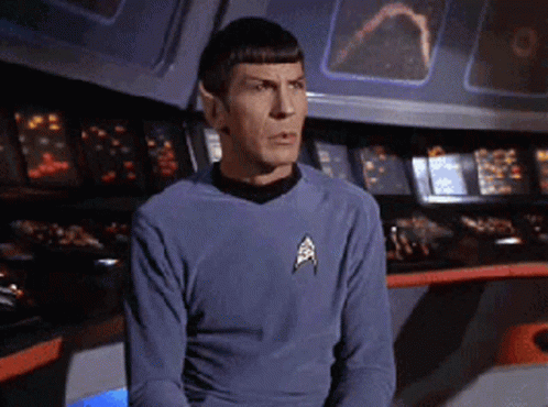A Man In A Star Trek Uniform Is Sitting In Front Of A Console GIF