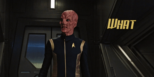 A Man In A Star Trek Uniform Is Standing In A Hallway With The Words What Is It You So Urgently Need My Help With GIF