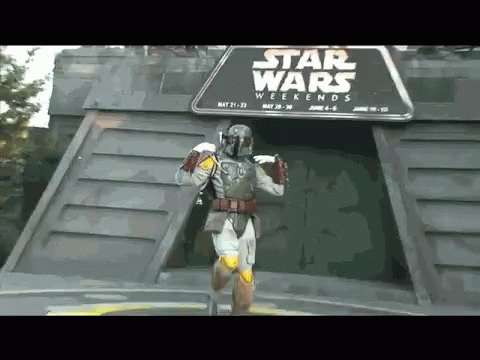 A Man In A Star Wars Costume Is Standing In Front Of A Star Wars Weekends Sign GIF