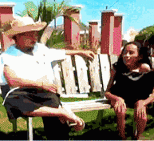 A Man In A Straw Hat Sits Next To A Woman GIF