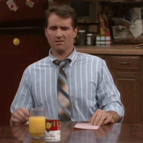Man In Striped Shirt And Tie Sitting At Table With Orange Juice GIF