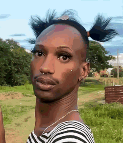 a man in a striped shirt has a nose ring and a necklace around his neck