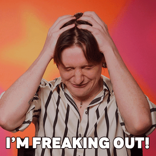 A Man In A Striped Shirt Has His Hands On His Head And The Words I 'M Freaking Out Above Him GIF