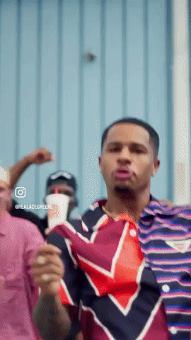 Man In Striped Shirt Dancing In Front Of Blue Wall GIF