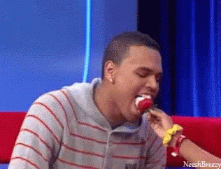 A Man In A Striped Shirt Is Eating A Lollipop With The Name Neeshbreezy On The Bottom GIF