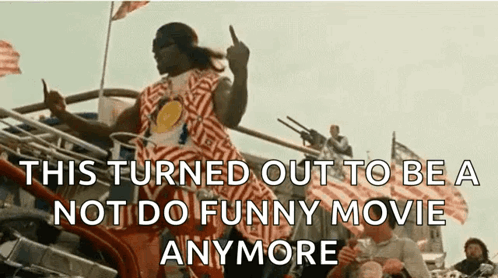 A Man In A Striped Shirt Is Giving The Middle Finger In Front Of A Crowd . GIF