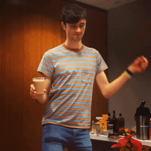 A Man In A Striped Shirt Is Holding A Cone GIF