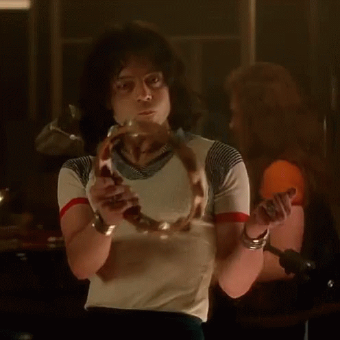 A Man In A Striped Shirt Is Holding A Snake In His Hand GIF