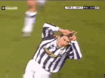 A Man In A Striped Shirt Is Kneeling Down On A Field GIF