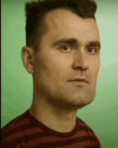 A Man In A Striped Shirt Is Looking At The Camera GIF