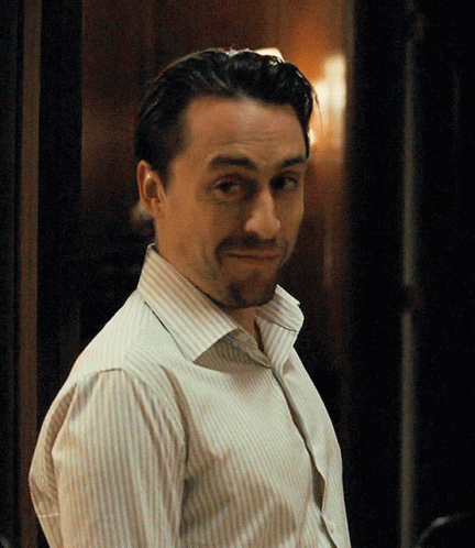 A Man In A Striped Shirt Is Making A Face GIF