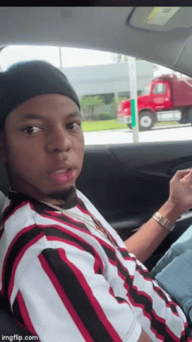 Man In Striped Shirt Looking At Phone In Car GIF