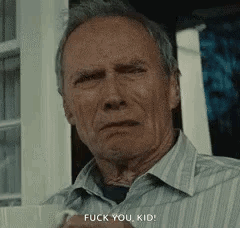 A Man In A Striped Shirt Is Standing In Front Of A Window And Says `` Fuck You Kid '' . GIF