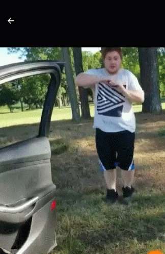 A Man In A Striped Shirt Is Standing Next To A Car Door GIF