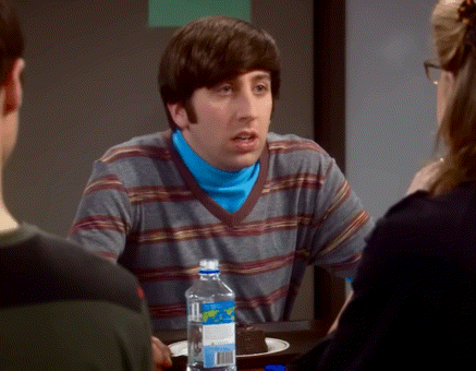a man in a striped shirt sits at a table with a bottle of aquafina water