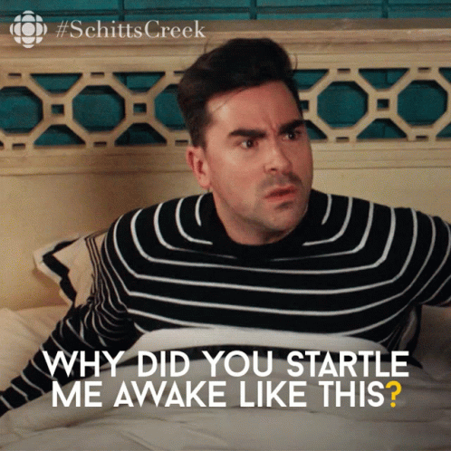 A Man In A Striped Sweater Is Laying On A Bed With The Words " Why Did You Startle Me Awake Like This " GIF