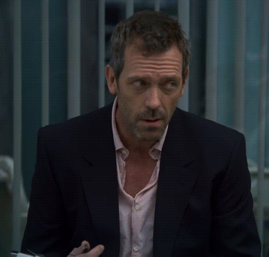 A Man In A Suit And A Pink Shirt Looks Serious GIF