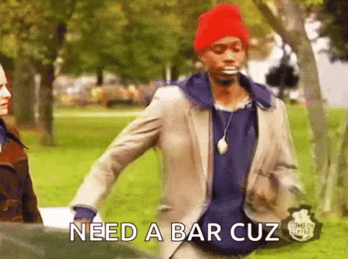 A Man In A Suit And A Red Hat Is Walking In A Park And Says Need A Bar Cuz GIF