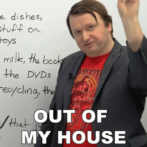 a man in a suit and a red shirt stands in front of a white board that says " out of my house "