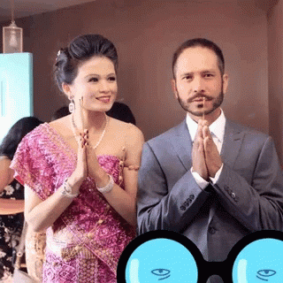 A Man In A Suit And A Woman In A Pink Dress Praying GIF