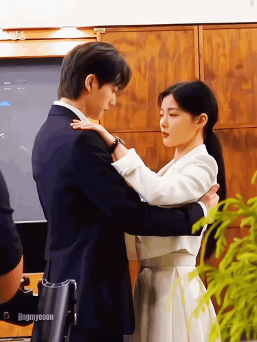 A Man In A Suit And A Woman In A White Dress Are Hugging Each Other With The Caption Jingmyeeoon GIF