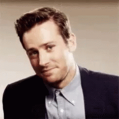 A Man In A Suit And Blue Shirt Is Making A Face . GIF