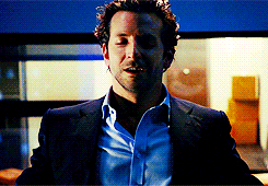 A Man In A Suit And Blue Shirt Is Standing In A Room GIF