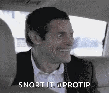 A Man In A Suit And Bow Tie Is Smiling In The Back Seat Of A Car . GIF