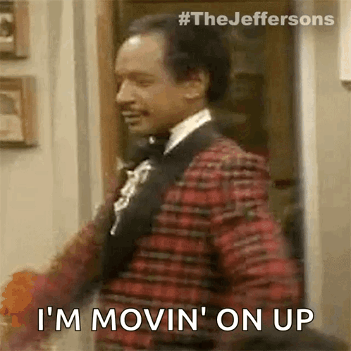 A Man In A Suit And Bow Tie Is Standing In A Doorway And Says `` I 'M Movin ' On Up '' GIF