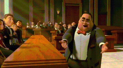 A Man In A Suit And Bow Tie Is Standing In Front Of A Group Of People . GIF