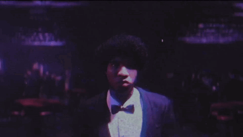Man In Suit And Bow Tie In Front Of Purple Background GIF