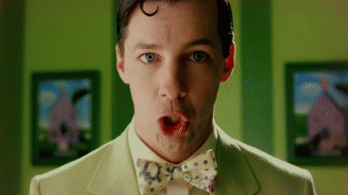 A Man In A Suit And Bow Tie Making A Surprised Face GIF