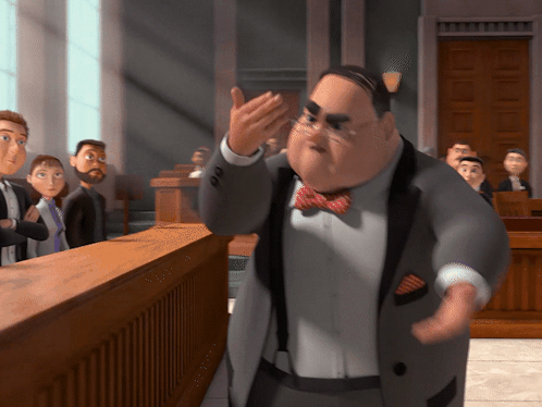 A Man In A Suit And Bow Tie Stands In Front Of A Jury GIF
