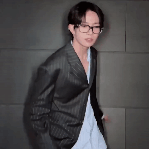 A Man In A Suit And Glasses Is Dancing GIF