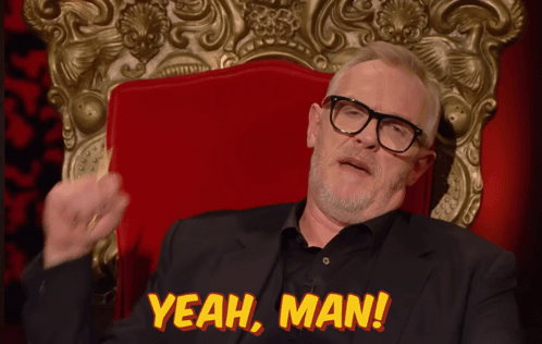 A Man In A Suit And Glasses Sits In A Red Chair With The Words Yeah Man Above Him GIF