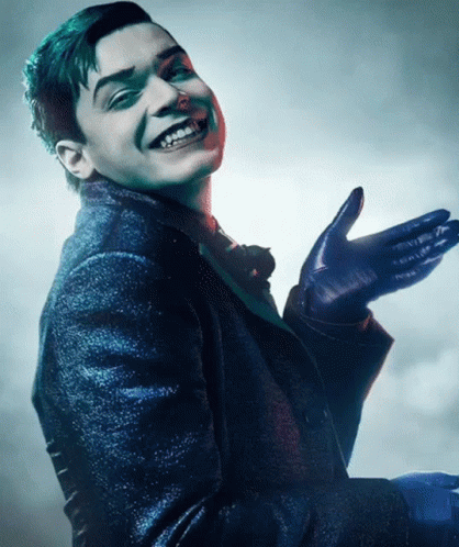 A Man In A Suit And Gloves Is Smiling With His Hand Outstretched GIF