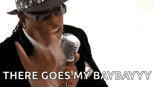 A Man In A Suit And Hat Is Singing Into A Microphone And Saying `` There Goes My Baybayyy '' . GIF