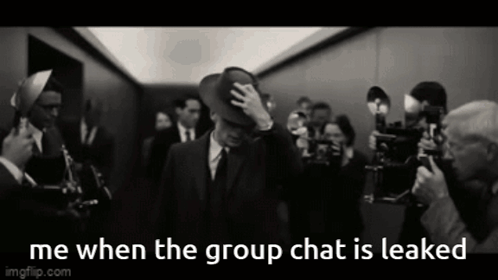 A Man In A Suit And Hat Is Surrounded By A Crowd Of People And The Caption Says Me When The Group Chat Is Leaked GIF