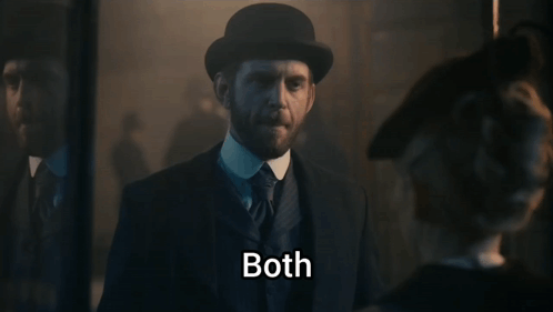 A Man In A Suit And Hat Says Both In A Dark Room GIF