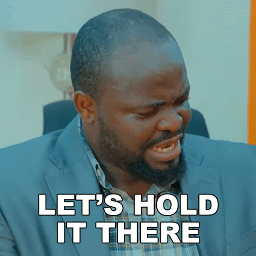 A Man In A Suit And Plaid Shirt Is Saying Let 'S Hold It There GIF