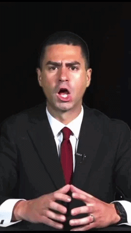 A Man In A Suit And Red Tie Is Making A Surprised Face GIF