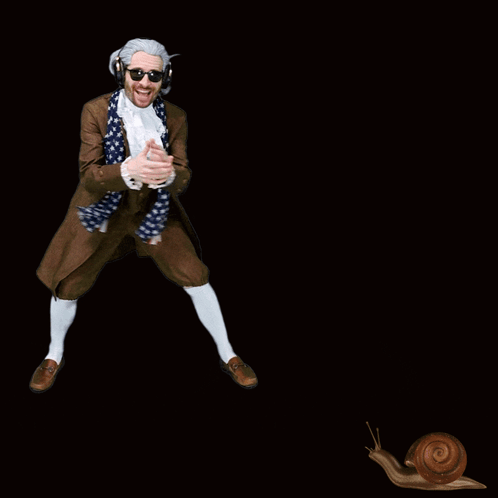 A Man In A Suit And Scarf Is Dancing With A Snail Behind Him GIF