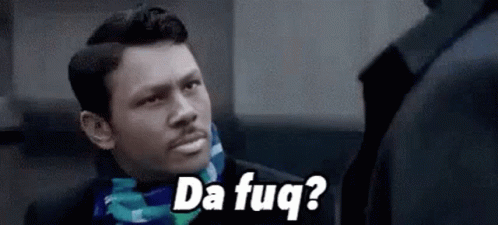 A Man In A Suit And Scarf Is Talking To Another Man While Wearing A Scarf . GIF