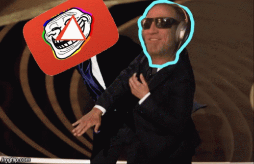 A Man In A Suit And Sunglasses Holds Up A Troll Face And A Youtube Logo GIF