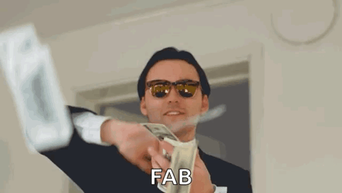 A Man In A Suit And Sunglasses Is Holding A Bunch Of Money In His Hands . GIF
