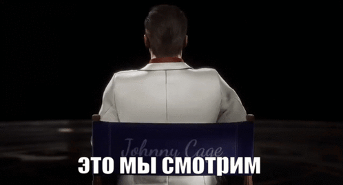 A Man In A Suit And Sunglasses Is Sitting In A Director 'S Chair With The Word Johnny Cage Written On It GIF