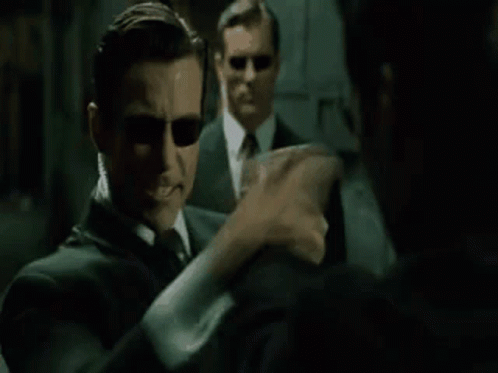 A Man In A Suit And Sunglasses Is Talking To Another Man In A Mirror And Says `` Hm , Upgrades '' . GIF