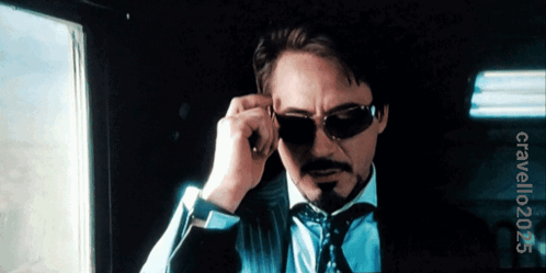 A Man In A Suit And Tie Adjusts His Sunglasses With A Watermark That Says Clavellooz3 On The Bottom GIF